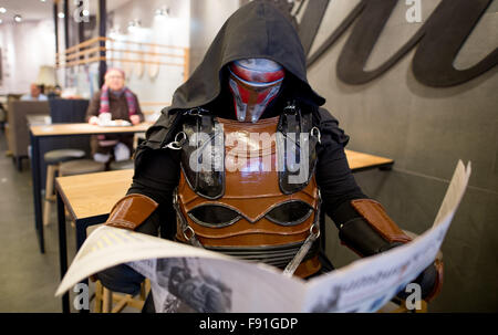 Hamburg, Deutschland. 14. November 2015. Ein Mitglied der Star Wars-Fan-Club liest die Zeitung, gekleidet wie die Filmfigur Darth Revan in einem Café in Hamburg, Deutschland, 14. November 2015. Teil sieben der Serie "Star Wars – das Erwachen der macht-Premiere in den deutschen Kinos am 17. Dezember 2015. Foto: Axel Heimken/Dpa/Alamy Live News Stockfoto