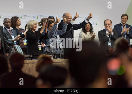 Paris, Frankreich. 12. Dezember 2015. Minister für auswärtige Angelegenheiten und designierter Präsident COP21 Laurent Fabius (C), hebt die Hände mit nach Annahme eines historischen globale Erwärmung Pakts auf der Klimakonferenz COP21 in Paris. © Jonathan Raa/Pacific Press/Alamy Live-Nachrichten Stockfoto