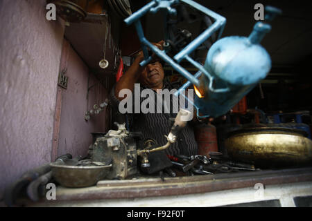 Kathmandu, Nepal. 13. Dezember 2015. Ein Ladenbesitzer eine alte traditionelle Schweißgas Ofen in Sinamangal, Kathmandu, Nepal auf Sonntag, 13. Dezember 2015. Viele Bürger haben begonnen, alte beschädigte Öfen für die Reparatur, aufgrund der laufenden Ölkrise für mehr als 3 Monate zu bringen. Foto/Skanda Gautam © Skanda Gautam/ZUMA Draht/Alamy Live-Nachrichten Stockfoto