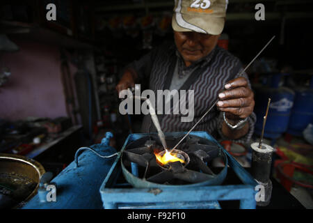 Kathmandu, Nepal. 13. Dezember 2015. Ein Ladenbesitzer eine alte traditionelle Schweißgas Ofen in Sinamangal, Kathmandu, Nepal auf Sonntag, 13. Dezember 2015. Viele Bürger haben begonnen, alte beschädigte Öfen für die Reparatur, aufgrund der laufenden Ölkrise für mehr als 3 Monate zu bringen. Foto/Skanda Gautam © Skanda Gautam/ZUMA Draht/Alamy Live-Nachrichten Stockfoto