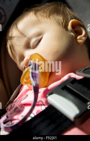9 Monate altes Babymädchen schläft in den Auto-Kindersitz
