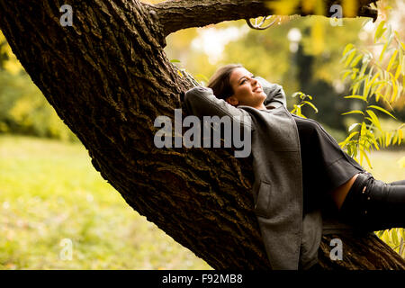 Oung Frau ruht auf dem Baum Stockfoto