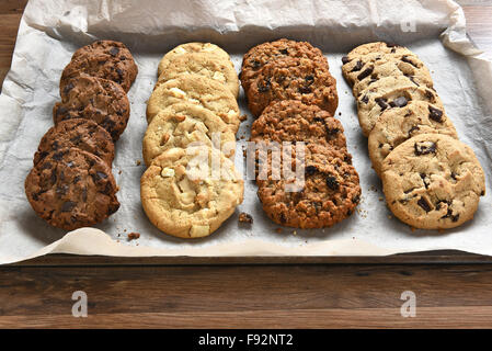 Nahaufnahme von einem Tablett mit frisch gebackene Kekse, Chocolate Chip, Haferflocken Rosinen Schokolade und weiße Schokoladenkekse auf Backen sh Stockfoto