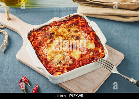 Gebackene anelletti Nudeln mit Hackfleisch, Soße und Mozzarella. Typische sizilianische Pasta mit Tomatensauce, Hackfleisch und Käse, im Ofen garen Stockfoto