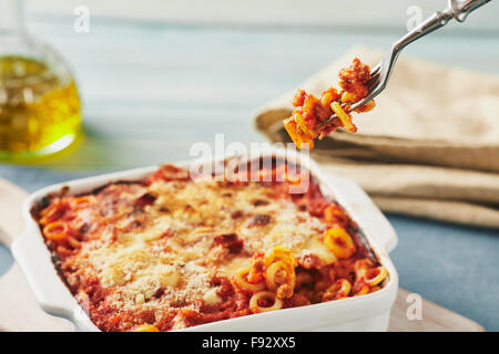 Gebackene anelletti Nudeln mit Hackfleisch, Soße und Mozzarella. Typische sizilianische Pasta mit Tomatensauce, Hackfleisch und Käse, im Ofen garen Stockfoto