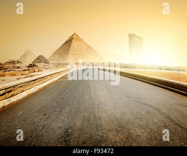 Asphaltierte Straße, Pyramiden und moderne Gebäude von Gizeh Stockfoto