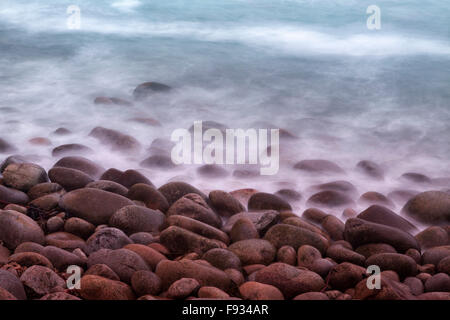 Wellen über Kieselsteine am Strand, Porth Nanven, in der Nähe von St. Just, Cornwall, England, Großbritannien Stockfoto