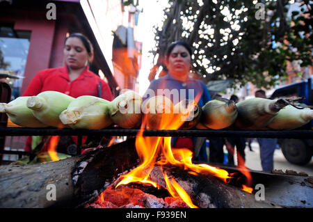 Kathmandu, Nepal. 13. Dezember 2015. Kamala Subedi (blauen Pullover), 38 Jahre und Alisa Khadka (rote Pullover), arbeitet 30 Jahre, ständigen Wohnsitz in Dolkha, als Straßenverkäufer in Kathmandu, geröstetem Mais zu verkaufen. Sie verwendet, um rohe Mais auf NRs. 11 (US$ 0,11) pro Stück zu kaufen und dann verkaufen sie geröstet von 25 (US$ 0,25) pro Stück wo sie NRS 1500 (15 US$) pro Tag zu verdienen. © Narayan Maharjan/Pacific Press/Alamy Live-Nachrichten Stockfoto