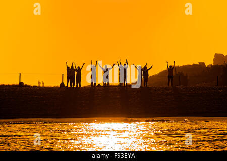 Gruppe von Menschen unter einem magischen Sonnenuntergang tun, Tai-Chi am Strand Rodas in Cíes-Inseln, Galicien, Spanien Stockfoto