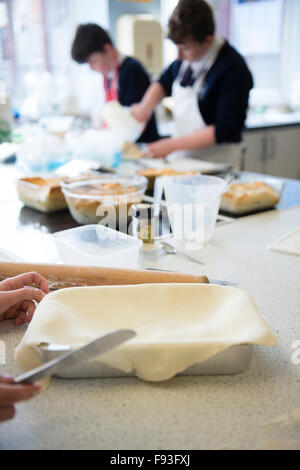 Sekundarstufe II Wales UK: junge Schüler Kochen in einer Lebensmittel-Technologie (Hauswirtschaft) Schule unterrichten Küche Klassenzimmer wird vorbereitet Stockfoto