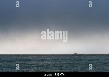 Ein einsamer Boot am Horizont unter ätherischen Himmel vor der Küste von Kent. Stockfoto