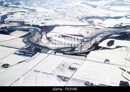 Luftaufnahme der schneebedeckten Prärielandschaft mit gewundenen Flüssen, Auen und Ackerland im Winter, Saskatchewan Stockfoto