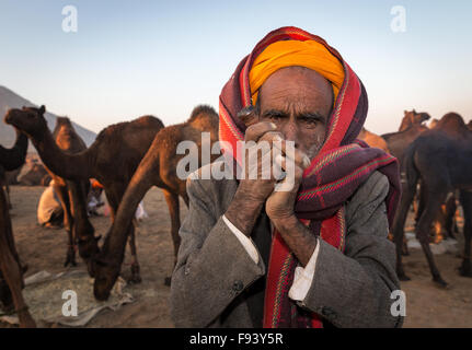 Ältere Rajasthani Mann mit einem Turban Rauchen ein Hash pipe, Pushkar, Rajasthan, Indien Stockfoto