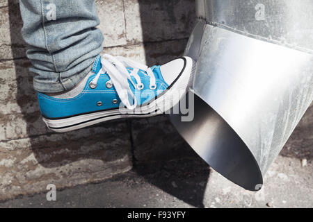 Teenager in der blaue Sneaker Kicks Abflußrohr, Aggression-Konzept Stockfoto