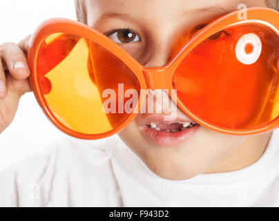 kleine niedlicher junge in orange Sonnenbrillen zeigen isolierte hautnah Teil des Gesichts Stockfoto