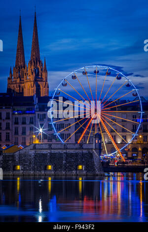 In der Nacht, ein großes Rad (Riesenrad) Spiegelung im Wasser an der Adour und Nive Fluss Mündung (Bayonne - Aquitaine - Frankreich). Stockfoto