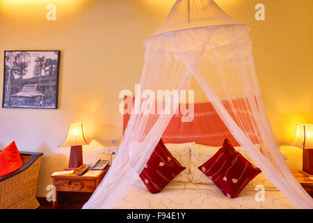 Bett mit Moskitonetz im Hotelzimmer. Siem Reap, Kambodscha. Stockfoto