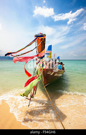 Traditionelles thailändisches Longtail-Boot mit farbenfrohen Bändern, das am Strand auf der Insel Poda (Koh Poda) festgemacht ist. Provinz Krabi, Thailand. Stockfoto