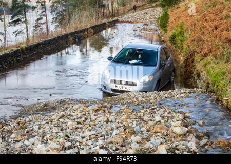 Ein Auto gefangen zwischen zwei Erdrutsche auf die A591, der Hauptstraße durch den Lake District, die durch das Hochwasser vom Sturm Desmond, Cumbria, UK komplett zerstört wurde. Die Straße wurde an mehreren Stellen durch Erdrutsche und Wände der Flut Debirs zwanzig Fuß hoch verletzt. die Straße wird wahrscheinlich seit Monaten geschlossen. Sonntag, 6. Dezember 2015 übernommen. Stockfoto