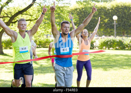 glückliche junge männliche Läufer gewinnen auf Rennen beenden Stockfoto