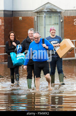 Die Ironie des t-Shirts. Carlisle Rugby Club-Mitglieder waten durch das Hochwasser in Carlisle, Cumbria auf Dienstag, 8. Dezember 2015, nach sintflutartigen Regen Sturm Desmond. Der Sturm setzen einen neuen britischen Rekord für Rainfsll Summen an einem Tag mit 341,4 mm in 24 Stunden fallen. Stockfoto