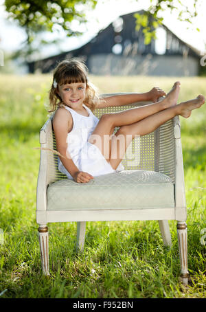 Niedliche kleine Mädchen ist in sonnigen, grünen Park Freizeit genießen. Stockfoto