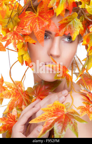 Schöne junge Frau eingewickelt im Herbst Blätter Stockfoto