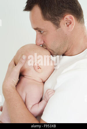 Junger Vater hält seinen neugeborenen Jungen. Stockfoto