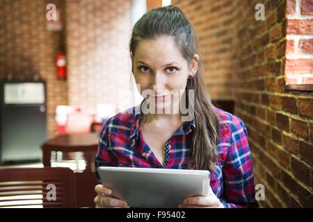 Lächelndes Mädchen verbringen Zeit in einem Café mit digital-Tablette Stockfoto