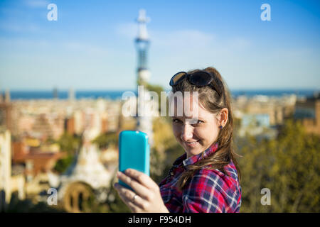 Hübsche junge weibliche Touristen nimmt Selfie im Parc Güell in Barcelona, Spanien. Stockfoto