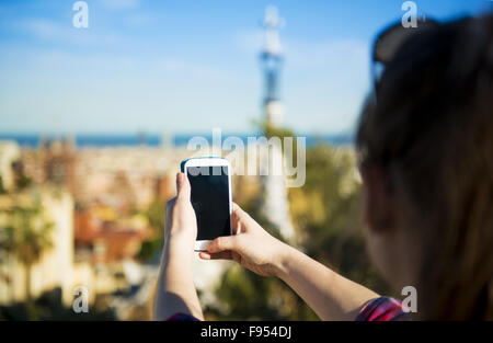 Hübsche junge weibliche Touristen nimmt Bild im Parc Güell in Barcelona, Spanien. Stockfoto