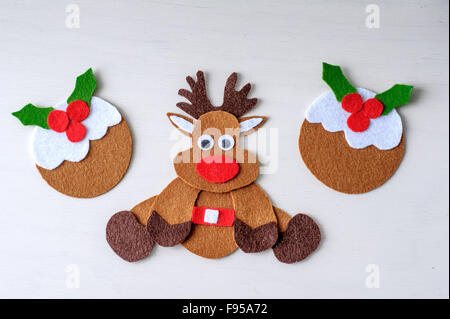 Grußkarte Handarbeit Weihnachten Rentier Rudolph aus Filz mit Christmas Pudding in der Winterzeit Stockfoto