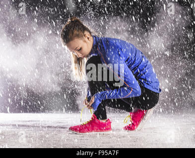 Athlet Frau läuft Wintertraining draußen im kalten Schneewetter. Stockfoto