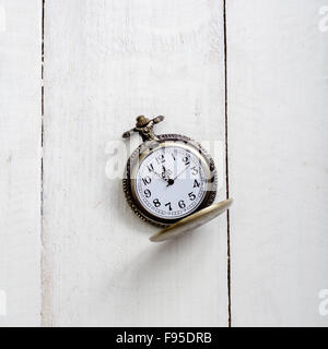 Antike Taschenuhr mit Kette Hintergrund rustikal im Alter von Holz mit Händen nähert sich 12:00 Stockfoto