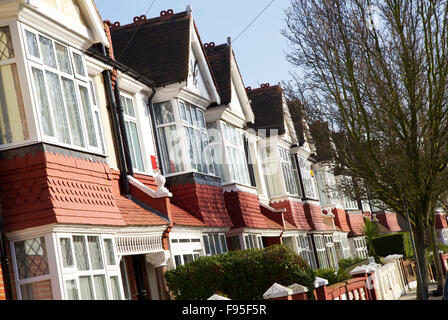 Hammersmith, London. Ansicht von Reihenhäusern in einer Wohnstraße in Hammersmith. Terrakotta-Putz-Fassade. Stockfoto