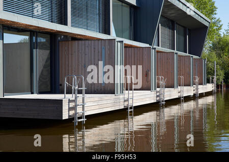 Wohnsiedlung am Neusiedler See, am Neusiedl See, Burgenland, Österreich. Außenansicht der sechs terrassenförmig angelegten Einheiten mit decking und Leiter Zugang zum See auf die zeitgenössische waterside Wohnsiedlung am Neusiedler am See, Burgenland, Österreich. Stockfoto