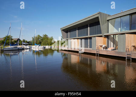 Wohnsiedlung am Neusiedler See, am Neusiedl See, Burgenland, Österreich. Yachten ankern über den See gegenüber der zeitgenössischen waterside Wohnsiedlung am Neusiedler bin sehen, Burgenland, Österreich. Stockfoto