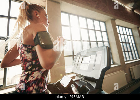 Young konzentrierte sich weibliche trainieren Sie im Fitnessstudio auf dem Laufband Joggen. Fitness-Frau laufen trainieren im Health Club. Stockfoto