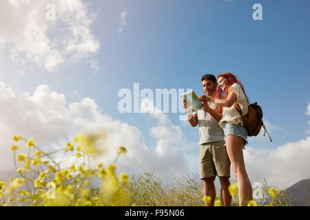 Junges Paar lesen Karte an Land gehen. Kaukasische Wanderer-paar auf Wanderung aussehende Richtungen auf Karte an einem Sommertag. Stockfoto