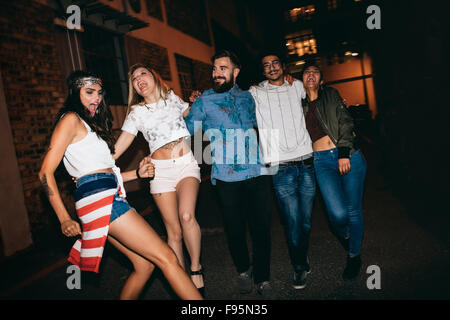 Fröhliche junge Menschen zusammen in der Nacht gehen und Spaß haben. Gemischtrassigen Gruppe befreundeter Abend hängen. Stockfoto