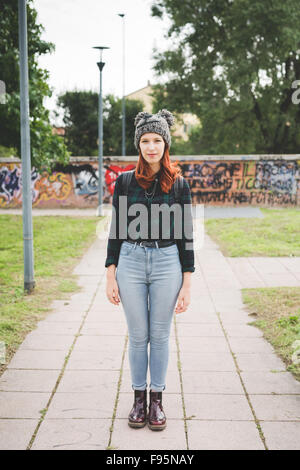 Junge hübsche Rothaarige kaukasischen glattes Haar Frau still zu stehen, auf der Suche in der Kamera, trägt Jeans, blau-grünes Hemd und Stockfoto