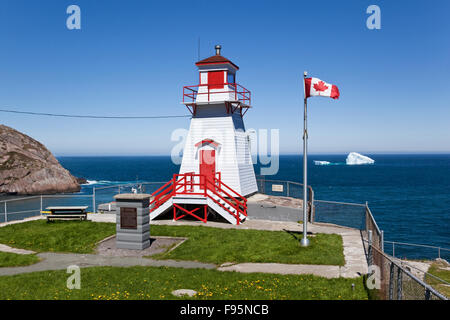 Fort Amherst Leuchtturm am Eingang zum Hafen St. Johns, Neufundland. Im Hintergrund sind zwei Eisbergen. Stockfoto