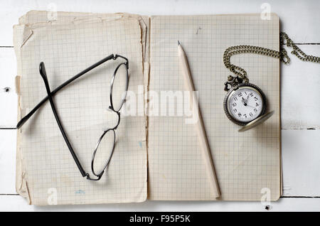 Notebook mit leeren Seiten, Stift und Vintage Taschenuhr auf hölzernen Hintergrund Stockfoto