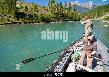 Mittelalterlichen Mann Fliegenfischen auf Bull Fluss mit Guide Rudern Fischerboot, Osten Kootenays, BC, Kanada. Stockfoto