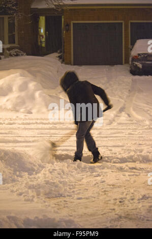 Frau, Reinigung Schnee von Einfahrt nach einem Schneesturm in Toronto Vororte Stockfoto