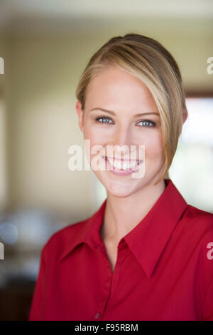 Porträt der jungen blonden Frau in roter Bluse Stockfoto