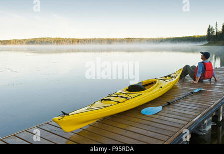 Mann und Kajak auf Dock, hängenden Herzen Seen, Prince Albert National Park, Saskatchewan, Kanada Stockfoto