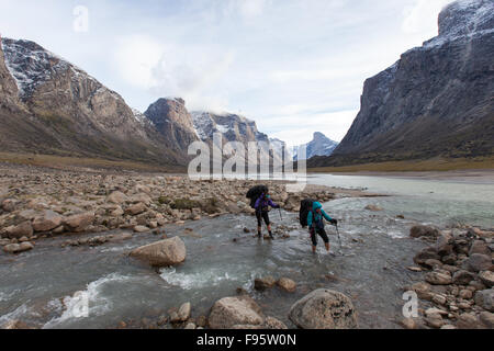 Wanderer durchqueren ein Baches im Auyuittuq-Nationalpark, Nunavut, Kanada Stockfoto