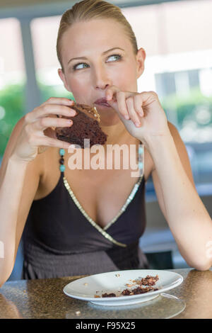 Junge, blonde Frau Schokolade Kuchen Stockfoto