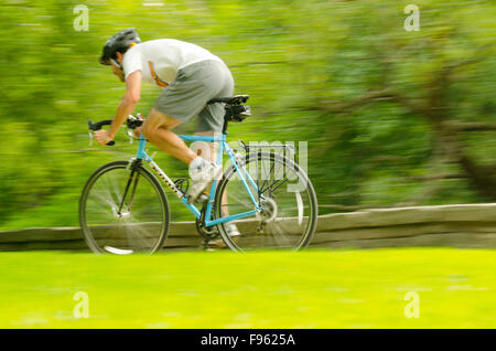 Ein Radfahrer durch die Stege und Wege pendeln im High Park, Toronto, Ontario Stockfoto